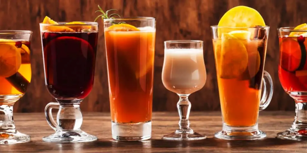 Selection of autumn hot and cold sangria drinks on wood background