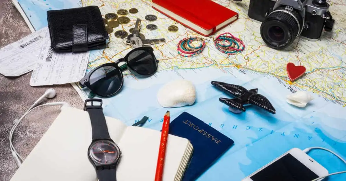 Travelers accessories including a map camera passport wallet and sunglasses