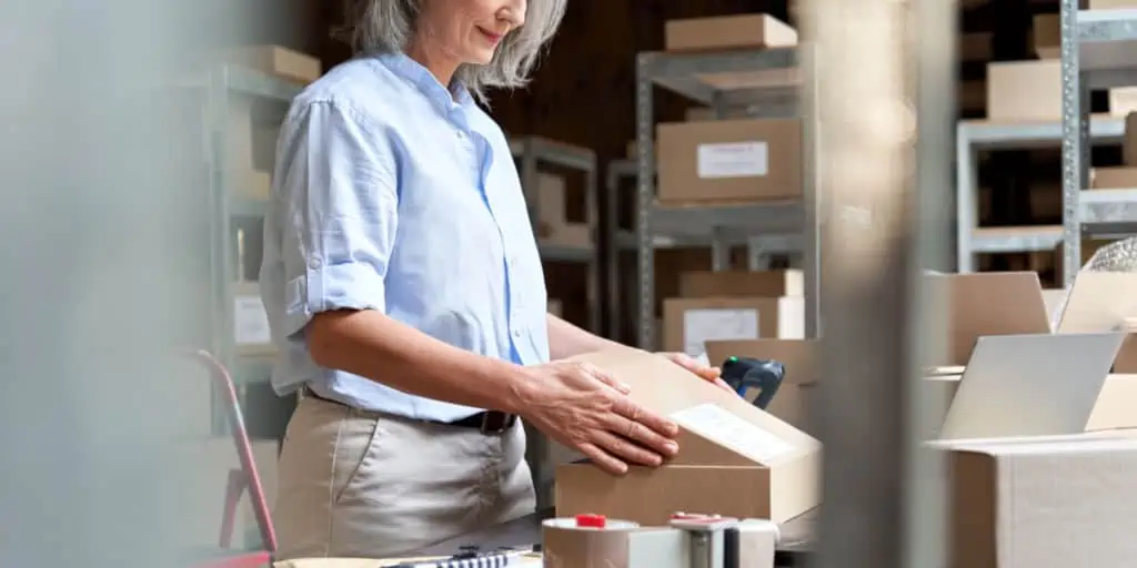 older female worker packaging a box at her part time job