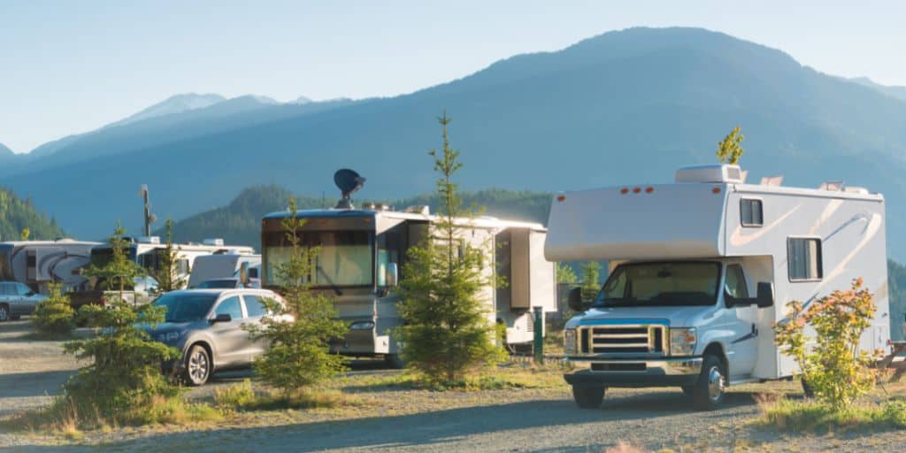 motorhomes and trailers at campground with mountains in background